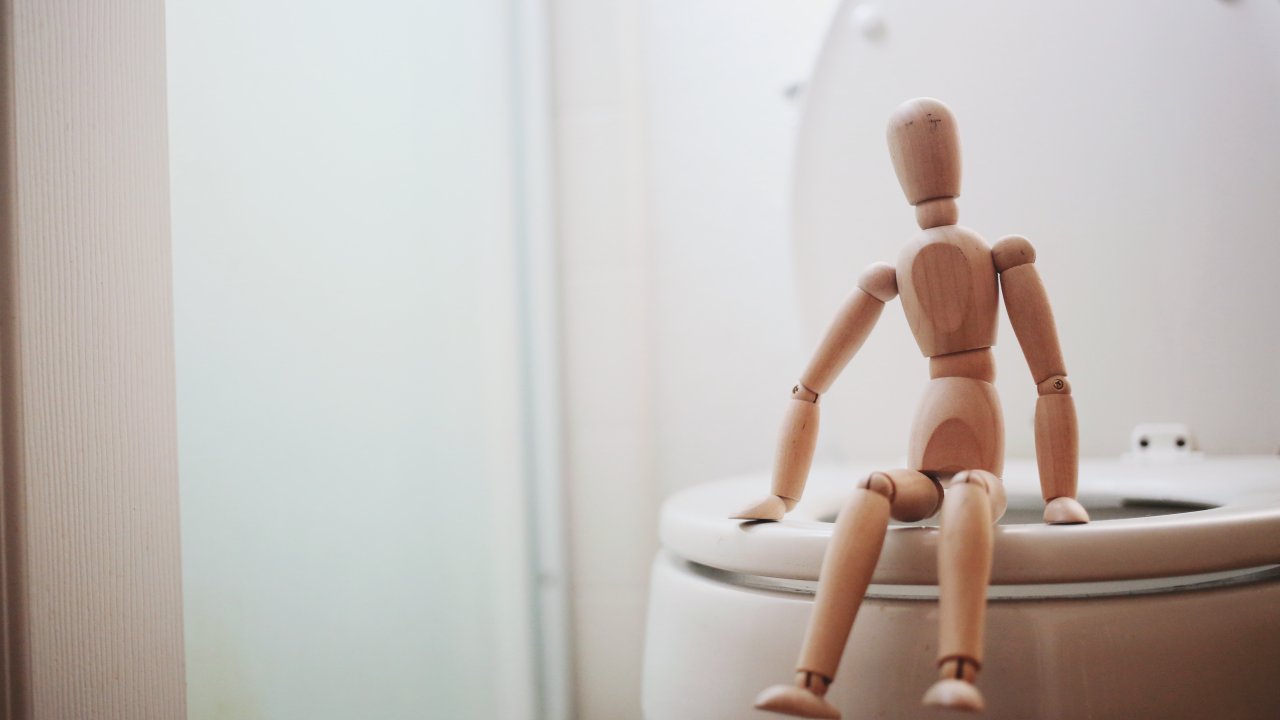 boneco sentado em um vaso sanitário